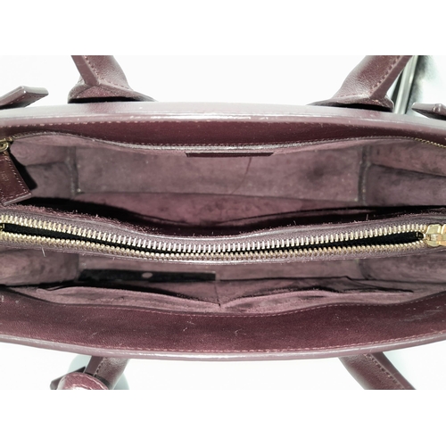 95 - A Saint Laurent Sac De Jour Burgundy Handbag. Leather Exterior, Gold Tone Hardware, Double Handle in... 