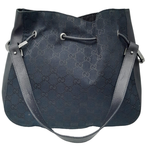 206 - A Gucci Black Monogram Drawstring Shoulder Bag. Canvas exterior with silver-toned hardware, leather ... 