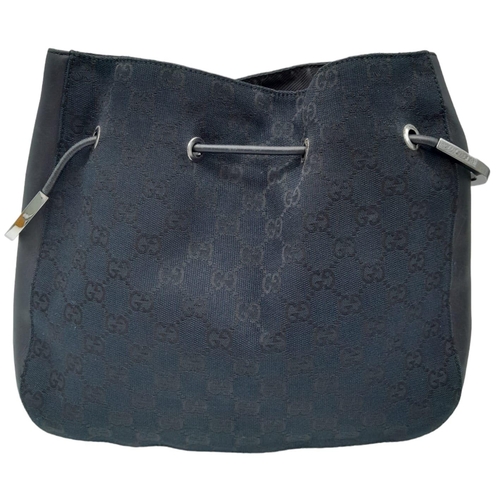 206 - A Gucci Black Monogram Drawstring Shoulder Bag. Canvas exterior with silver-toned hardware, leather ... 