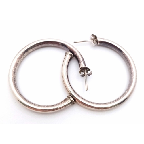 991 - A vintage pair of sterling silver hoop earrings. Total weight 9.85G.