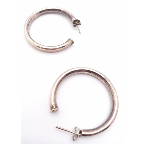 991 - A vintage pair of sterling silver hoop earrings. Total weight 9.85G.