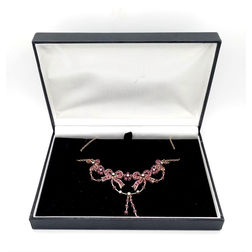 1208 - An Art Deco Style 9K Yellow Gold Ruby and Diamond Lavaliere Necklace. Floral and bow decoration. 40c... 