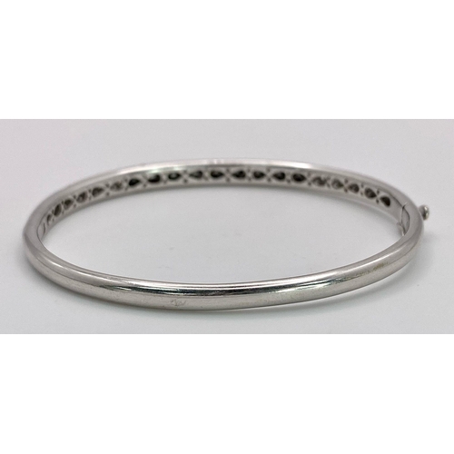 1030 - AN 18K WHITE GOLD BANGLE WITH BLACK AND WHITE QUALITY DIAMONDS.  17.3gms