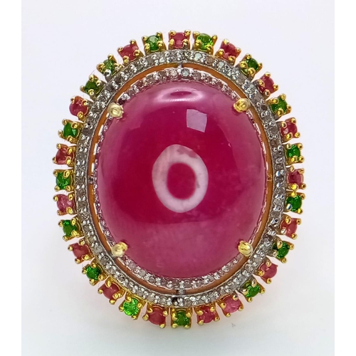 829 - A Ruby Cabochon Ring with a Halo of Tourmalines and Diamonds on 925 Silver. Approximately 10ct ruby,... 