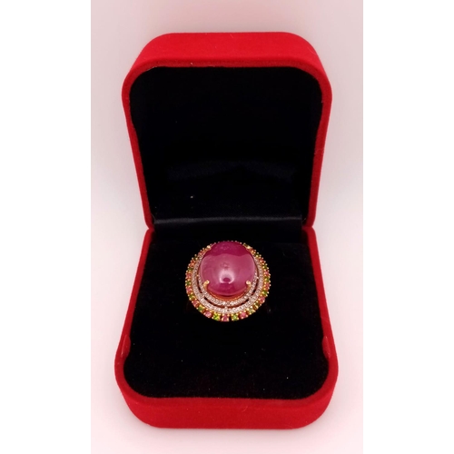 829 - A Ruby Cabochon Ring with a Halo of Tourmalines and Diamonds on 925 Silver. Approximately 10ct ruby,... 