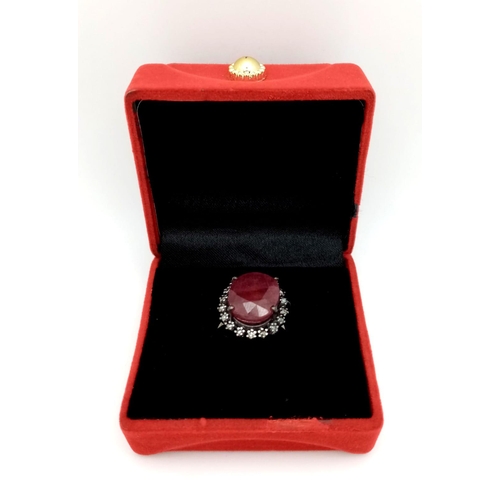 1088 - A Ruby Ring with a Halo of Diamonds on 925 Silver. 12.65ct ruby, 0.50ctw diamonds. Size P, 7.21g tot... 