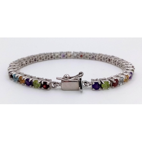 569 - A Multi-gemstone Tennis Bracelet set in 925 Silver. Amethyst Citrine, Topaz and Peridot. 18cm length... 