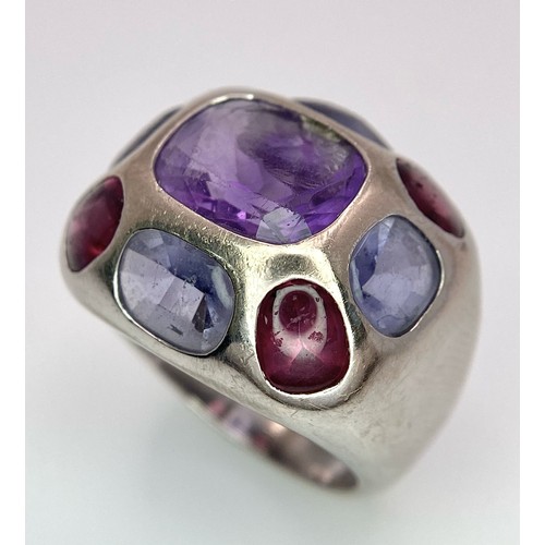 45 - A Chanel Designer 18K White Gold and Amethyst and Garnet Ring. Rectangular cut central amethyst with... 