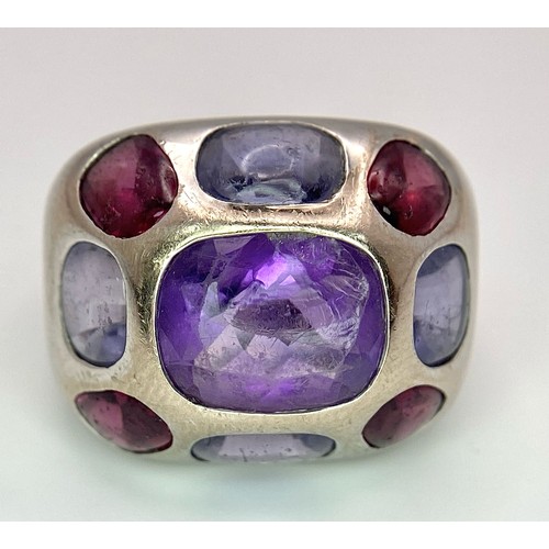 45 - A Chanel Designer 18K White Gold and Amethyst and Garnet Ring. Rectangular cut central amethyst with... 