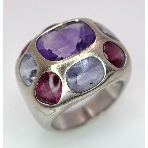 45 - A Chanel Designer 18K White Gold and Amethyst and Garnet Ring. Rectangular cut central amethyst with... 