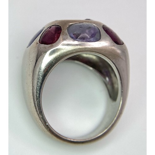 45 - A Chanel Designer 18K White Gold and Amethyst and Garnet Ring. Rectangular cut central amethyst with... 