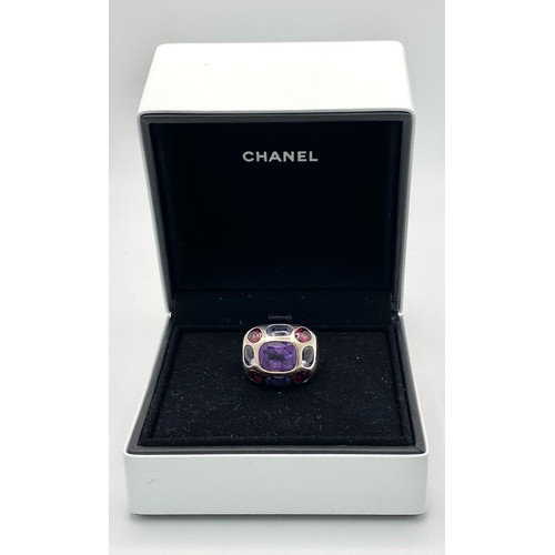 45 - A Chanel Designer 18K White Gold and Amethyst and Garnet Ring. Rectangular cut central amethyst with... 