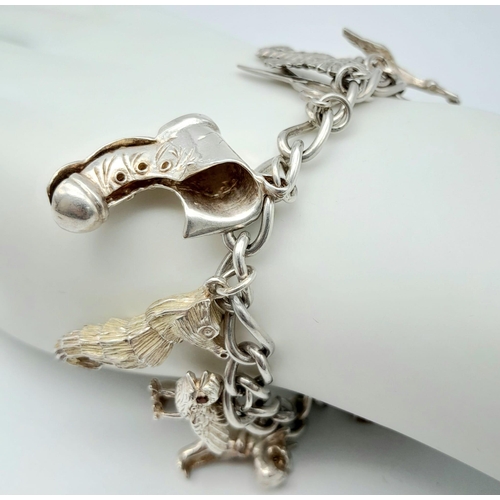 1362 - A vintage sterling silver link chunky bracelet with multiple charms such as Owl  with Ruby eyes stan... 