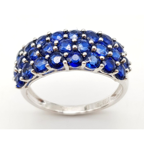 1245 - A 9K White Gold Three Row Sapphire Ring. 25 small round cut sapphires. Size R. 3.7g total weight.