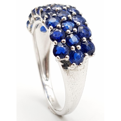 1245 - A 9K White Gold Three Row Sapphire Ring. 25 small round cut sapphires. Size R. 3.7g total weight.