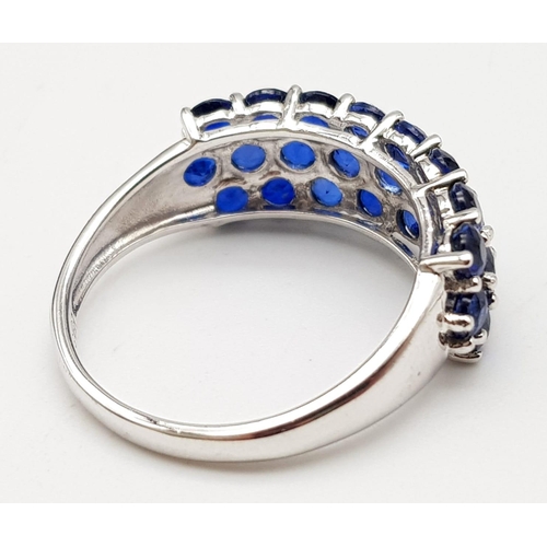 1245 - A 9K White Gold Three Row Sapphire Ring. 25 small round cut sapphires. Size R. 3.7g total weight.