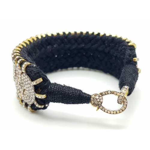 1202 - A Brilliantly Unique Handcrafted Designer Diamond Bracelet. A black woven textile bracelet strap ado... 