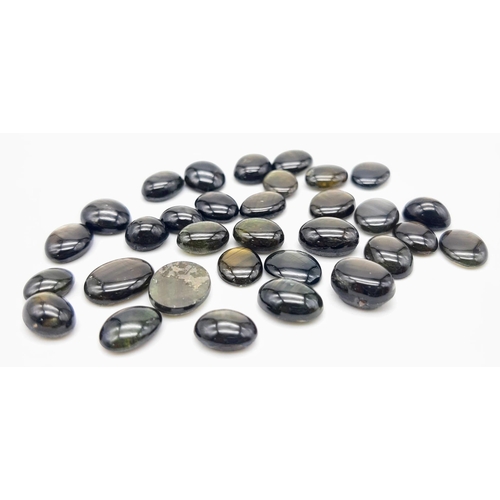 1308 - A Parcel of 32 Black Star Diopside Oval Cabochons. 63.54 Carats Total.