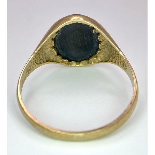 17 - A Vintage 9K Yellow Gold Onyx Signet Ring. Carved centurion decoration. Size T. 3g total weight.