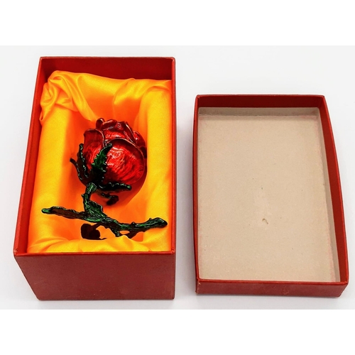 220 - An intriguing enamelled red rose ring presentation case, which -when opened- reveals a stunning, one... 