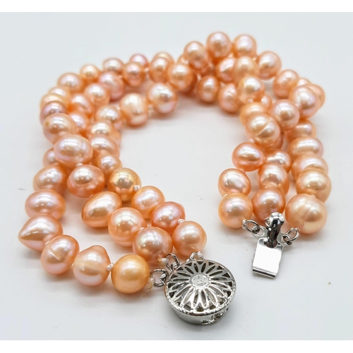 227 - A fashionable three strand of high quality, natural pink pearls necklace, bracelet and earrings set ... 