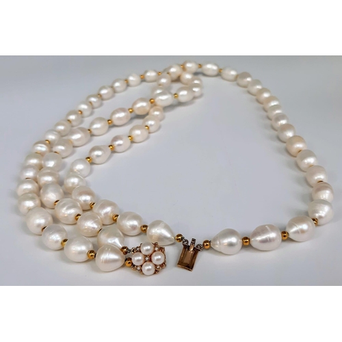 241 - A very desirable, two strand white, natural pearl necklace in an unusual design, adorned with a 9 K ... 