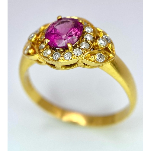 45 - An 18K Yellow Gold Pink Sapphire and Diamond Ring. Central oval sapphire with diamond halo and diamo... 