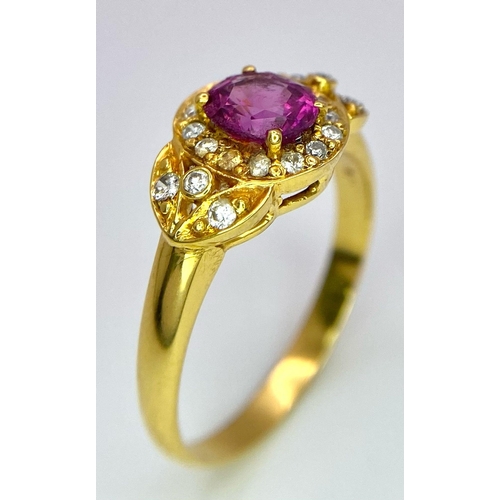 45 - An 18K Yellow Gold Pink Sapphire and Diamond Ring. Central oval sapphire with diamond halo and diamo... 