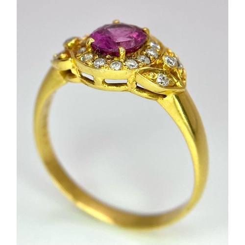 45 - An 18K Yellow Gold Pink Sapphire and Diamond Ring. Central oval sapphire with diamond halo and diamo... 