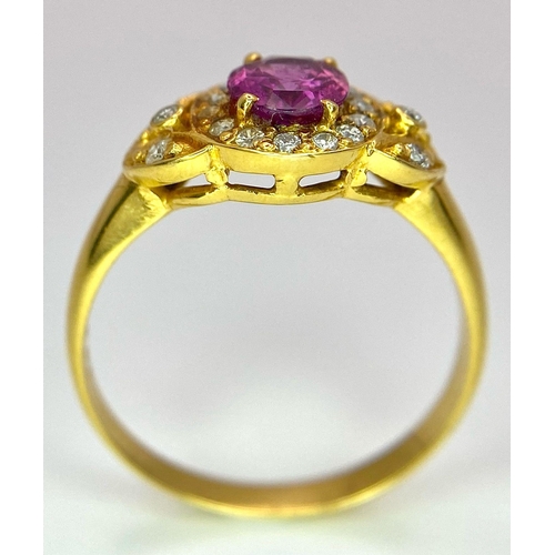 45 - An 18K Yellow Gold Pink Sapphire and Diamond Ring. Central oval sapphire with diamond halo and diamo... 