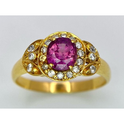 45 - An 18K Yellow Gold Pink Sapphire and Diamond Ring. Central oval sapphire with diamond halo and diamo... 