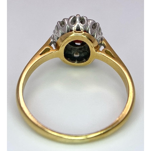 148 - An 18K Yellow Gold Garnet and Diamond Ring. Central oval garnet with diamond surround. Size K. 3.2g ... 