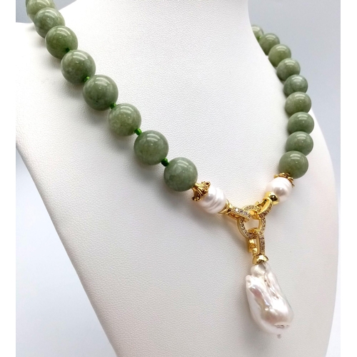 449 - A Keisha Baroque Pearl Pendant on a Pale Green Jade Necklace. White stone accents and gilded clasp. ... 