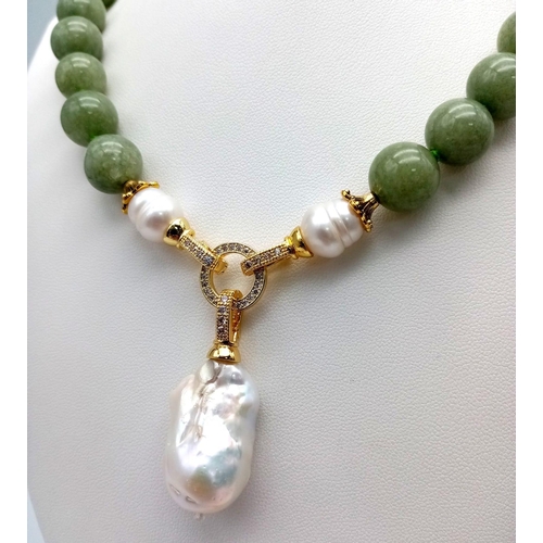 449 - A Keisha Baroque Pearl Pendant on a Pale Green Jade Necklace. White stone accents and gilded clasp. ... 