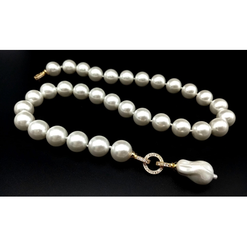 687 - A Baroque Shaped Pearl Shell Pendant on a South Sea White Pearl Shell Necklace. Gilded clasps and wh... 