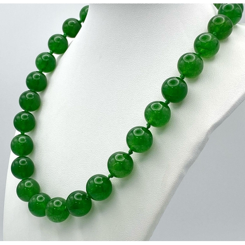 724 - A Classic Dark Green Jade Bead Necklace. 14mm bead size. 42cm necklace length.