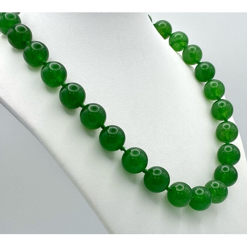 724 - A Classic Dark Green Jade Bead Necklace. 14mm bead size. 42cm necklace length.