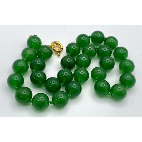 724 - A Classic Dark Green Jade Bead Necklace. 14mm bead size. 42cm necklace length.