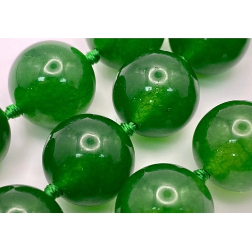 724 - A Classic Dark Green Jade Bead Necklace. 14mm bead size. 42cm necklace length.