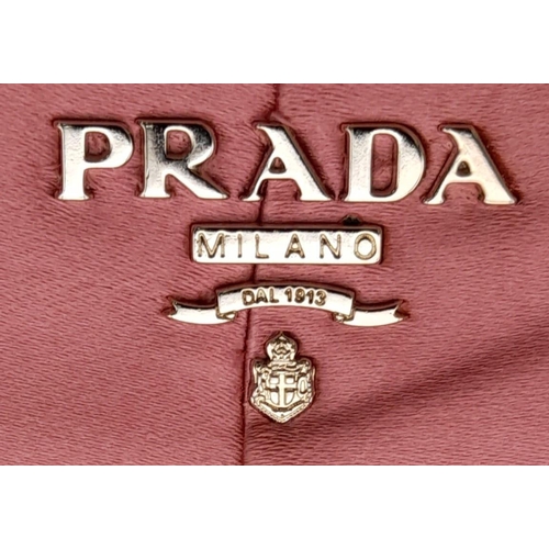 1296 - A Prada Pink Pleated Clutch Bag. Satin exterior with silver-toned hardware and press lock closure to... 