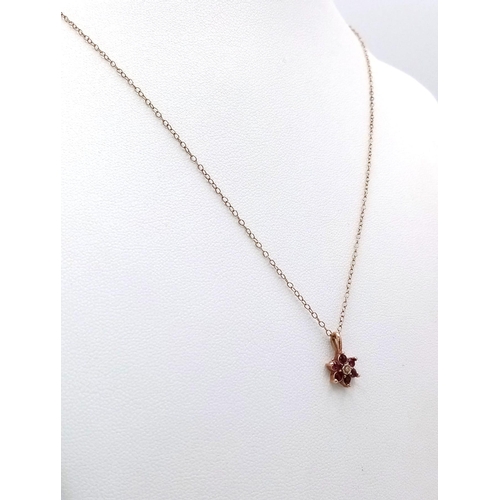 709 - A 9K Yellow Gold Ruby and Diamond Small Floral Pendant on a 9K Yellow Gold Disappearing Necklace. Pe... 