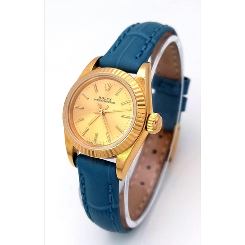 168 - An 18k Gold Rolex Oyster Perpetual Ladies Watch. Blue leather strap. 18k gold case - 25mm. Gold tone... 