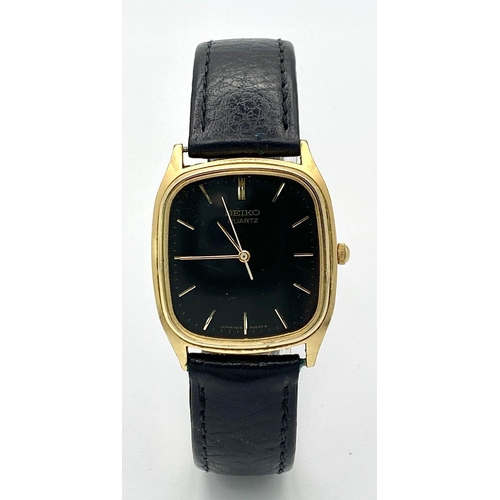 261 - A gold plated, steel SEIKO watch, case: 32 x 29 mm, black dial with gold coloured hour marks and han... 