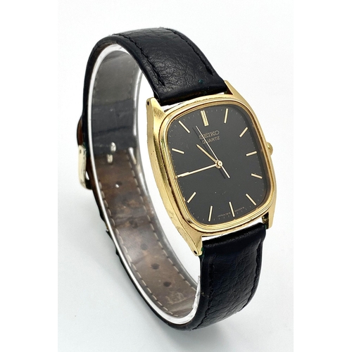 261 - A gold plated, steel SEIKO watch, case: 32 x 29 mm, black dial with gold coloured hour marks and han... 