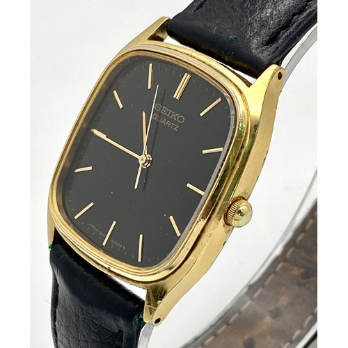 261 - A gold plated, steel SEIKO watch, case: 32 x 29 mm, black dial with gold coloured hour marks and han... 