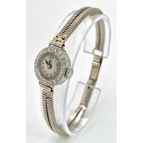 6 - A ladies, platinum watch with diamond bezel and a 9 K white gold double snake chain bracelet. The qu... 