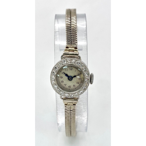 6 - A ladies, platinum watch with diamond bezel and a 9 K white gold double snake chain bracelet. The qu... 