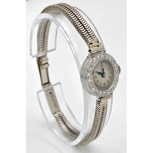 6 - A ladies, platinum watch with diamond bezel and a 9 K white gold double snake chain bracelet. The qu... 