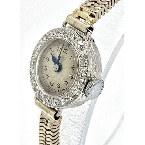 6 - A ladies, platinum watch with diamond bezel and a 9 K white gold double snake chain bracelet. The qu... 