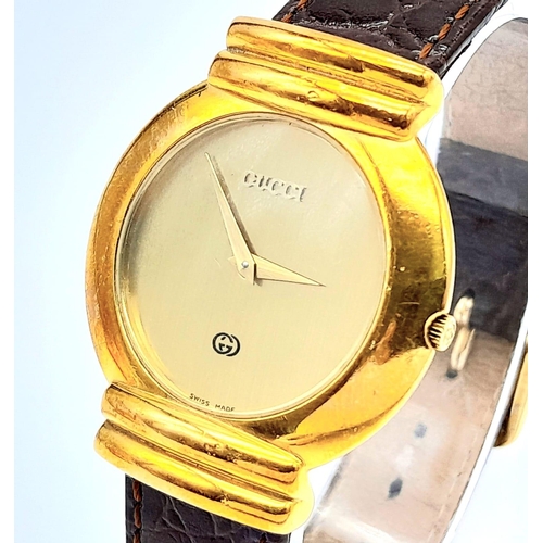 275 - A gold plated GUCCI with crocodile skin strap, case: 33 mm, gold coloured dial and hands, Swiss made... 